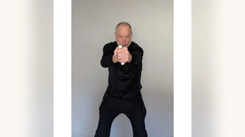 Van gripping both ShoulderBack Pro handles in front of his chest, one in each fist