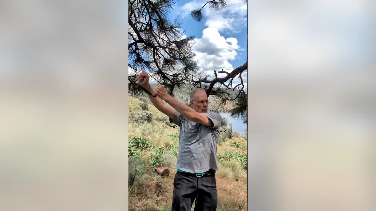 Van demonstrating the SeeSaw.Jpg movement with the ShoulderBack Pro outdoors — a frame from the routine video
