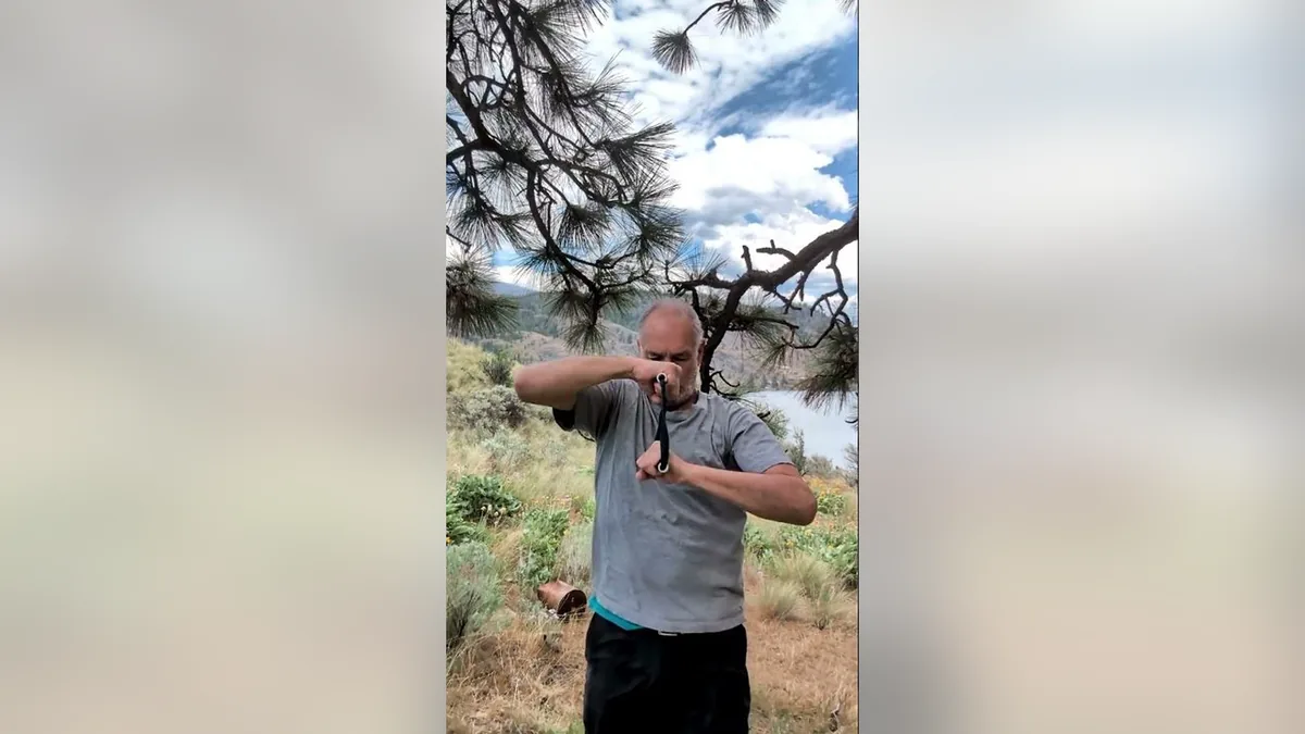 Van demonstrating the Arm Wrestler.Jpg movement with the ShoulderBack Pro outdoors — a frame from the routine video