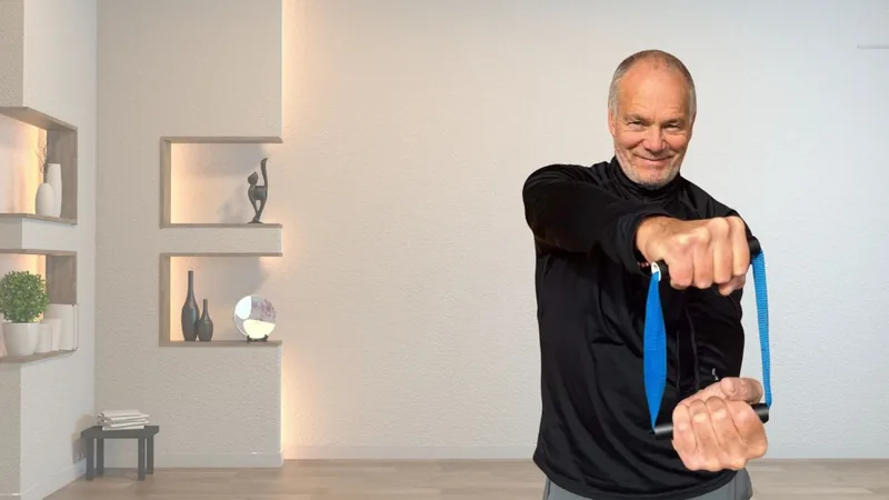 Van, founder of ShoulderBack Pro, standing in a bright room pulling the trainer across his body with both hands