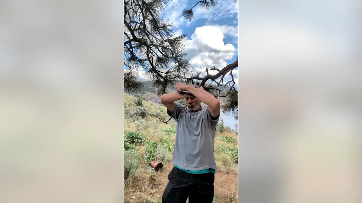 Van demonstrating the Bear Hugs You.Jpg movement with the ShoulderBack Pro outdoors — a frame from the routine video