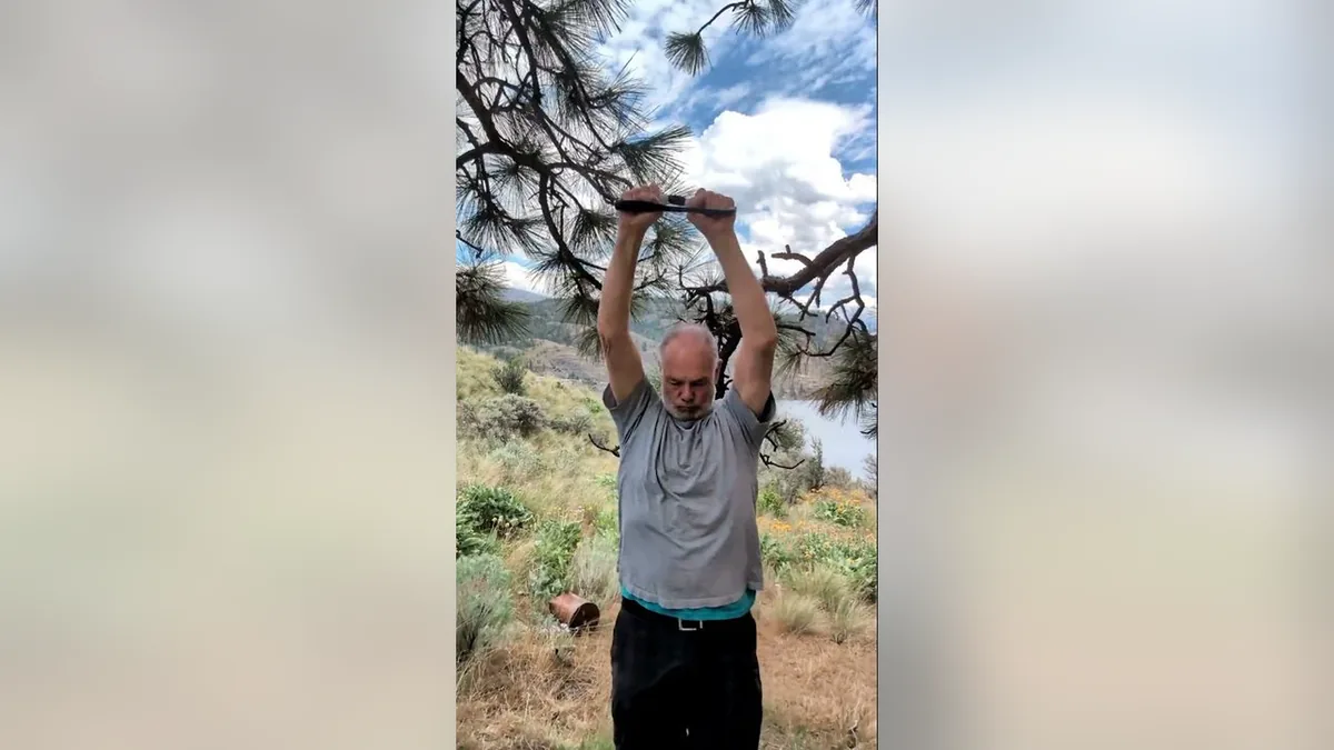 Van demonstrating the Grinders.Jpg movement with the ShoulderBack Pro outdoors — a frame from the routine video