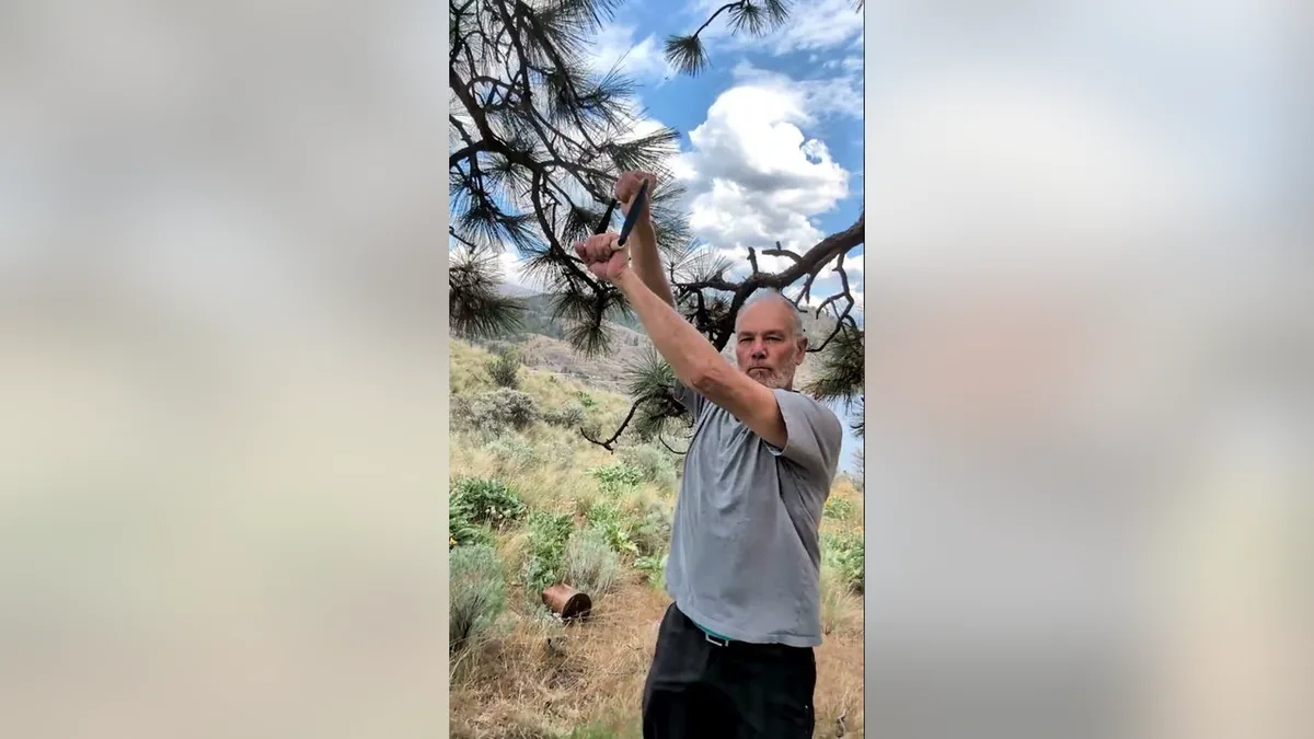 Van demonstrating the Dumbbell Raise.Jpg movement with the ShoulderBack Pro outdoors — a frame from the routine video