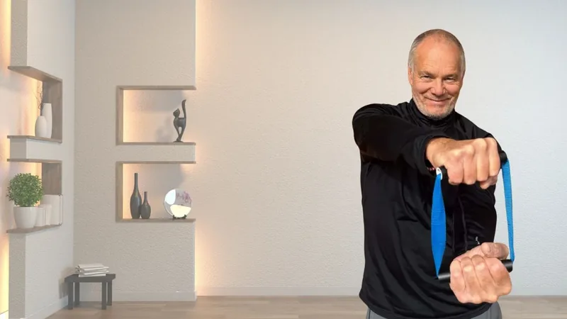 Van, founder of ShoulderBack Pro, standing in a bright room pulling the trainer across his body with both hands