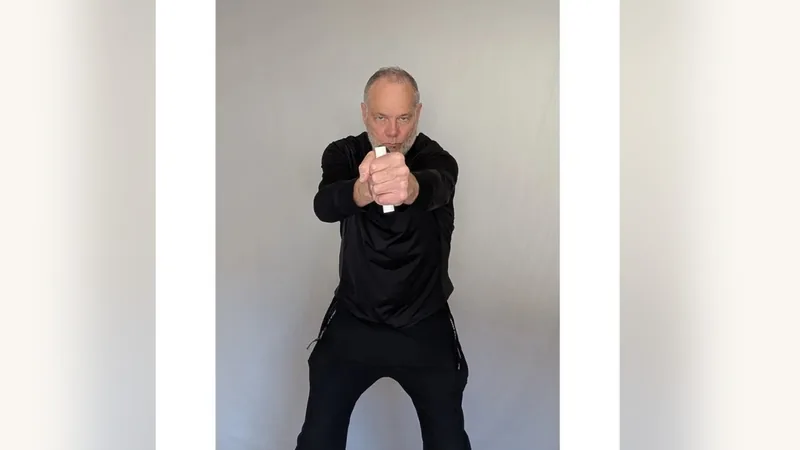 Van gripping both ShoulderBack Pro handles in front of his chest, one in each fist