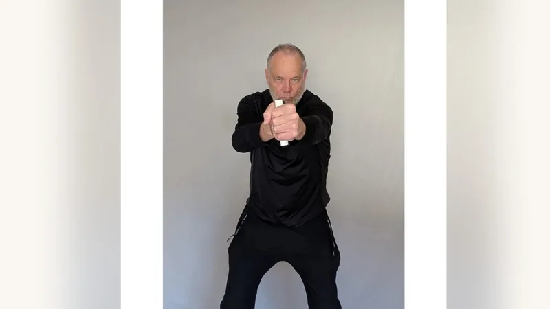Van gripping both ShoulderBack Pro handles in front of his chest, one in each fist