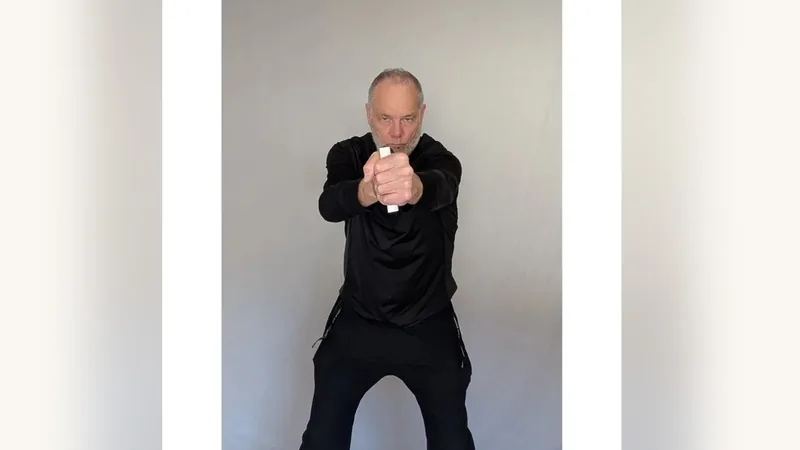 Van gripping both ShoulderBack Pro handles in front of his chest, one in each fist