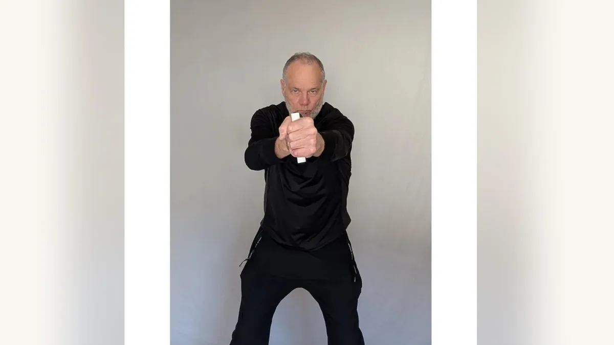 Van gripping both ShoulderBack Pro handles in front of his chest, one in each fist
