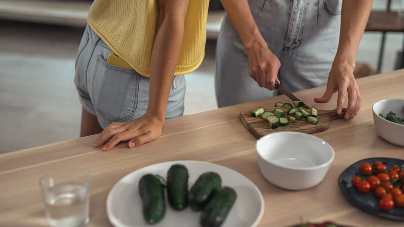 A glass of water and a neatly arranged plate of vegetables on a kitchen counter
