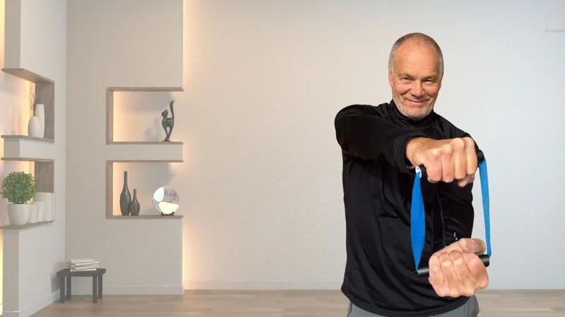 Van, founder of ShoulderBack Pro, standing in a bright room pulling the trainer across his body with both hands